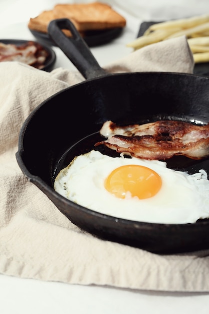 Desayuno de huevos y tocino frito en la sartén