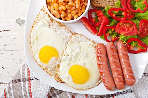 Desayuno inglés: salchichas, huevos, frijoles y ensalada.