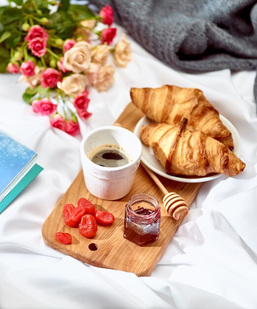 Desayuno en una mesa de madera y flores.