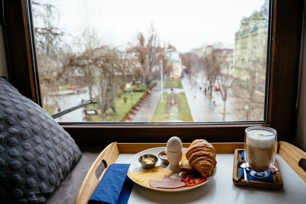 Desayuno en una mesa de madera junto a la ventana