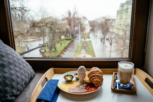 Desayuno en una mesa de madera junto a la ventana