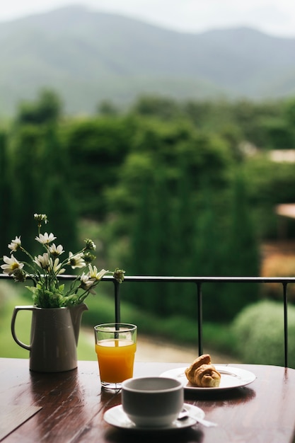 Desayuno en mesa de madera con vista natural