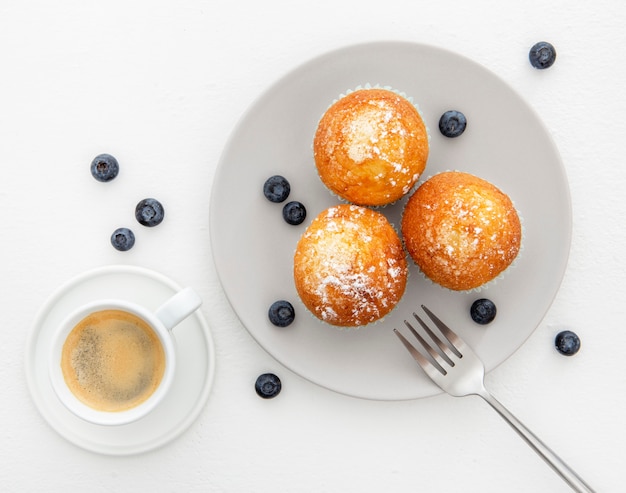 Foto gratuita desayuno con muffins y café plano.