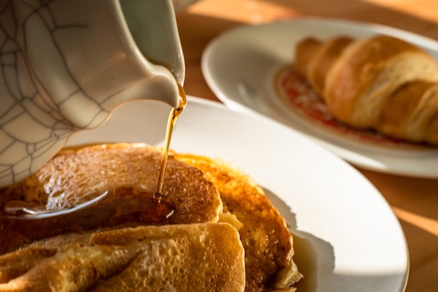 Un desayuno de panqueques y croissant