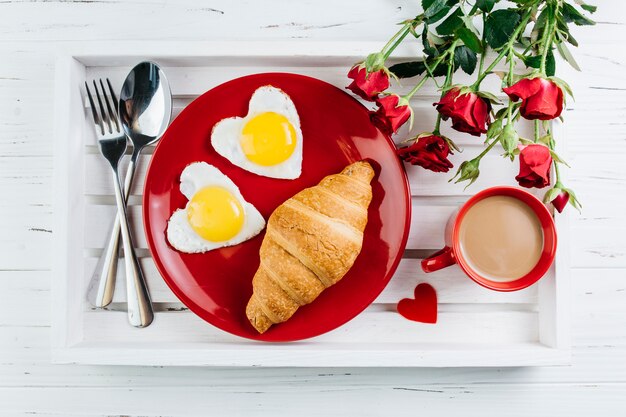 Desayuno romántico en bandeja de madera.