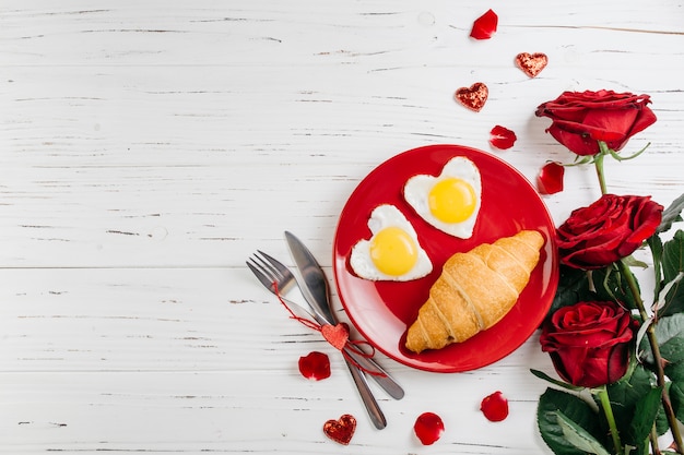 Desayuno romántico en mesa de madera clara.