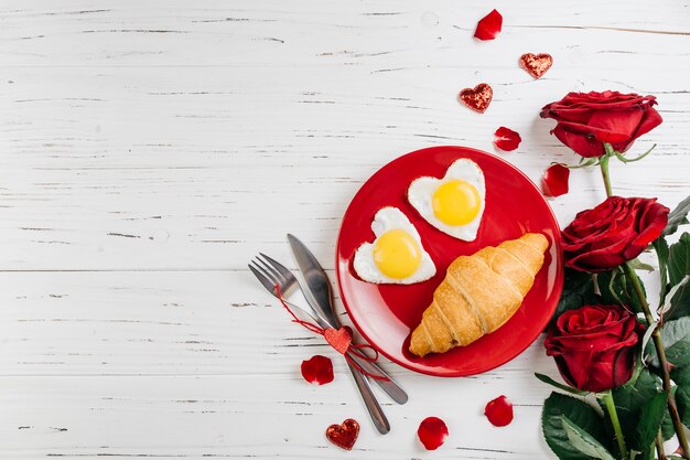 Desayuno romántico en mesa de madera clara.