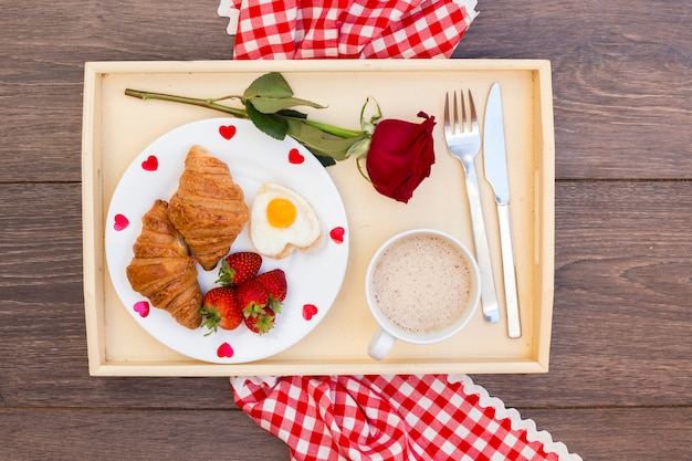 Desayuno romántico servido en bandeja.