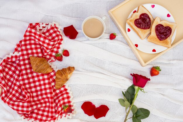 Desayuno romántico servido en tela blanca.