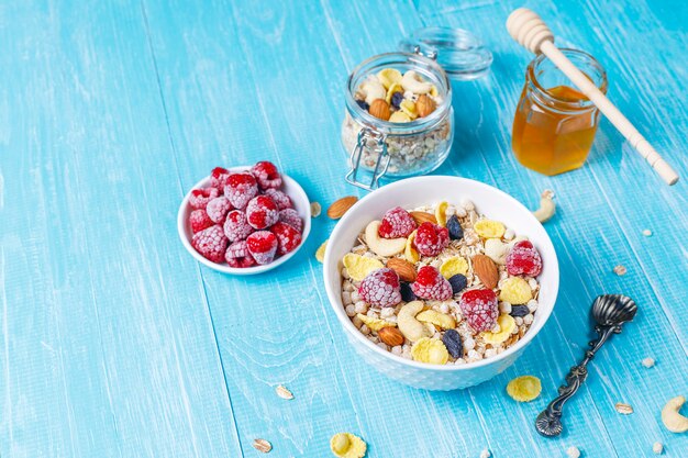 Desayuno saludable. Granola fresca, muesli con nueces y bayas congeladas