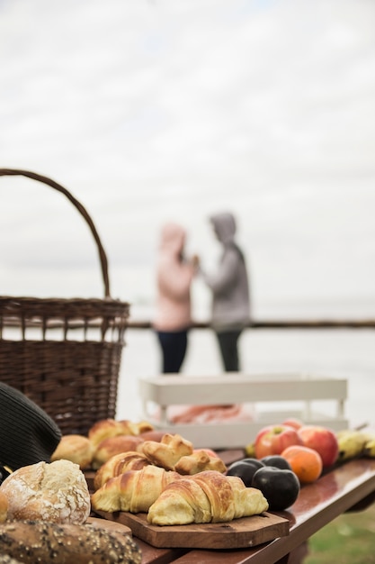 Desayuno sobre la mesa con pareja al fondo.