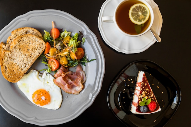 Desayuno; Te de limón; Pastel de queso o fondo negro de las bayas