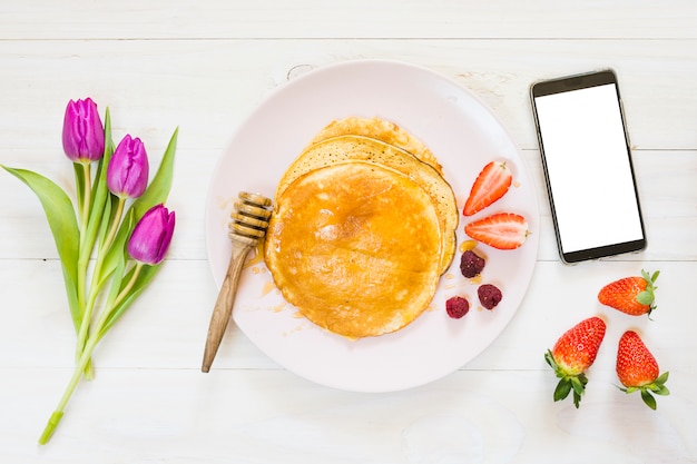 Foto gratuita desayuno de tortitas con móvil