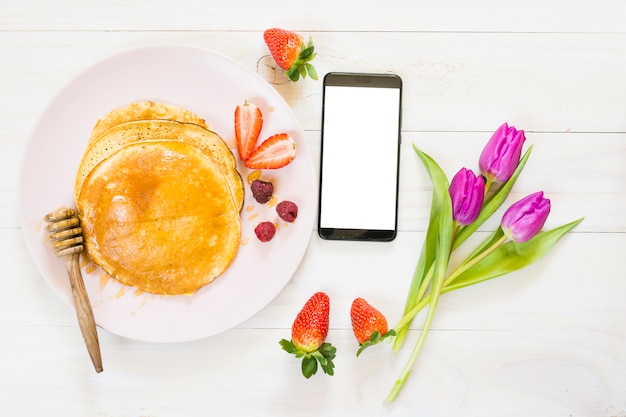 Foto gratuita desayuno de tortitas con móvil