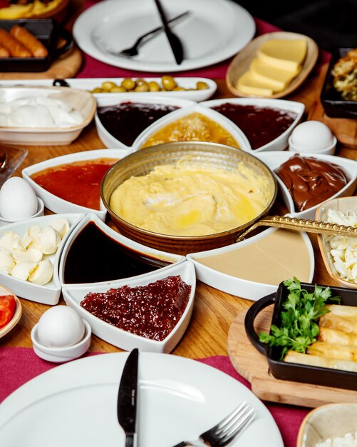 Desayuno turco con mermeladas de queso, plato de huevo, mantequilla de chocolate y otros