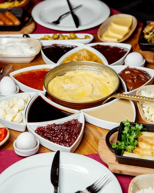 Desayuno turco con mermeladas de queso, plato de huevo, mantequilla de chocolate y otros