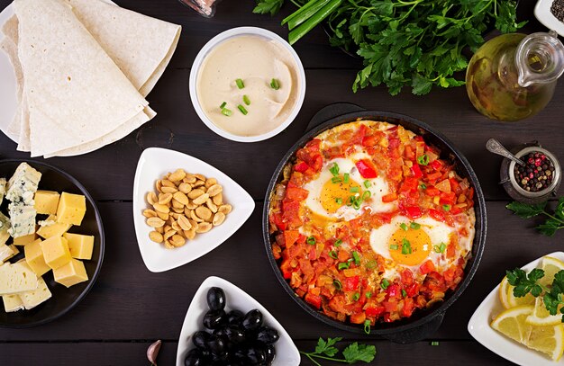 Desayuno turco Shakshuka, aceitunas, queso y fruta. Rico brunch.