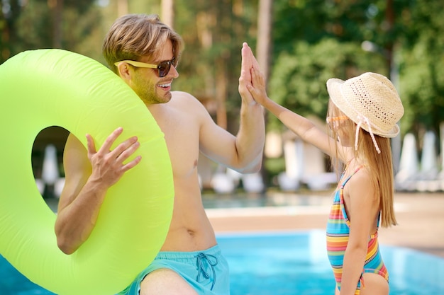 descanso de verano. Joven y su hijo en la piscina.