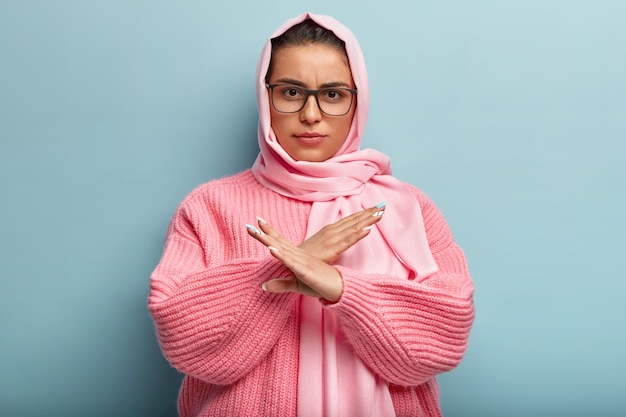 Foto gratuita descontento mujer morena seria con apariencia especifica, muestra gesto cruzado en prohibicion, dice no me preguntes al respecto, expresa disconformidad y disgusto. detente, basta, concepto de rechazo