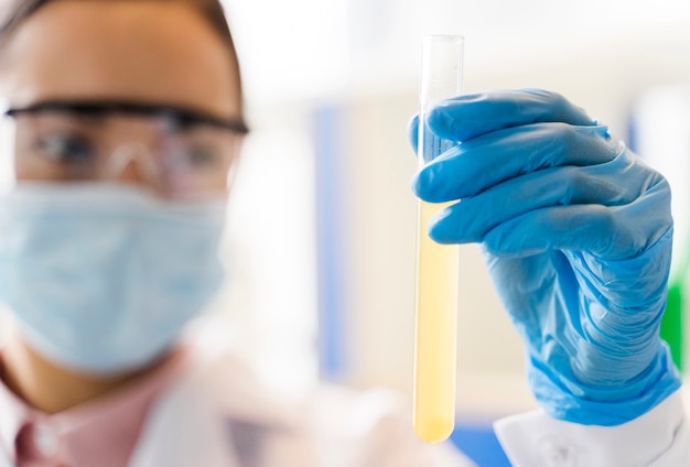 Desenfocado científico femenino con sustancia de laboratorio