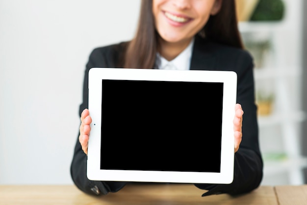 Desenfoque de empresaria sonriente mostrando pantalla en blanco en tableta digital
