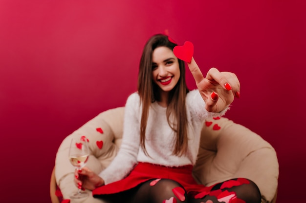 Foto gratuita desenfoque de retrato de niña de pelo largo con su mano sosteniendo el corazón en foco