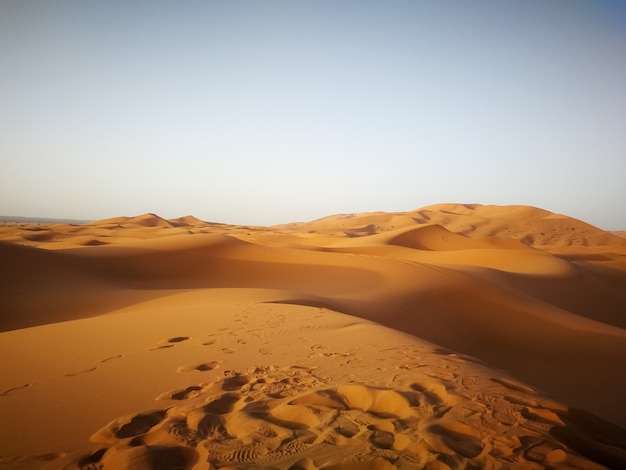 Desierto del Sahara bajo la luz del sol y un cielo azul en Marruecos en África