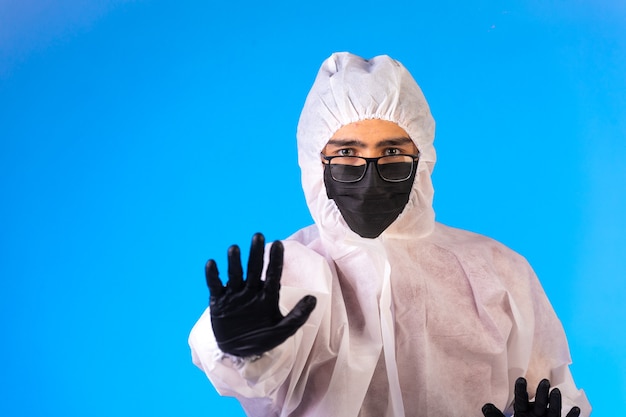 Desinfectante en uniforme preventivo especial y mascarillas detiene el peligro con una mano.