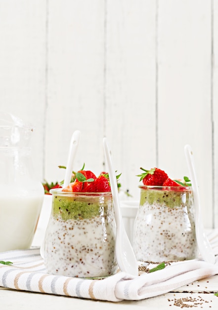 Desintoxicación y súper alimentos saludables desayuno en frasco. Vegan leche de coco semillas de chia pudín con fresas y kiwi.