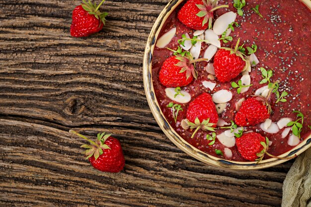 Desintoxicación y súper alimentos saludables desayuno en un tazón. Budín vegano de semillas de chía con fresas y almendras. Batido de fresas Vista superior. Lay Flat