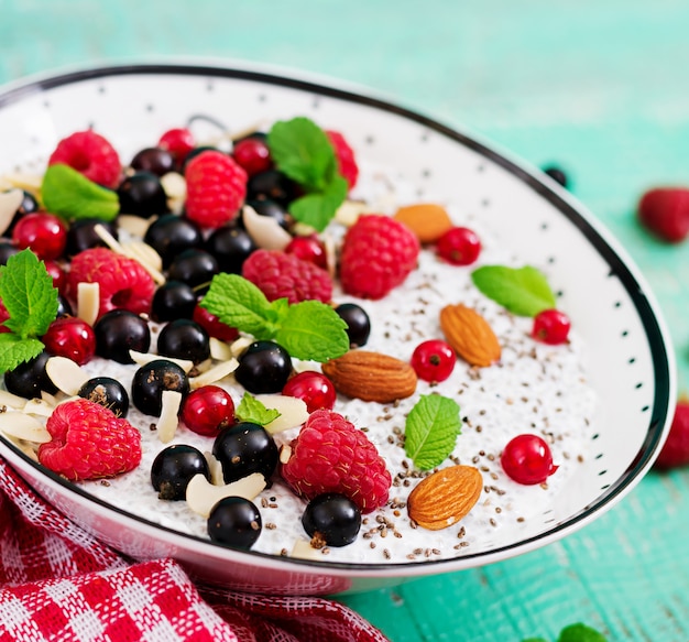 Desintoxicación y súper alimentos saludables desayuno en un tazón. Pudín de semillas de chía con leche de almendras veganas con frambuesas, moras y menta.