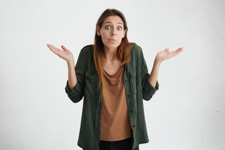 Foto gratuito desorientada mujer desconcertada con los ojos muy abiertos que tiene dudas y se encoge de hombros expresando incertidumbre. a nadie le importa