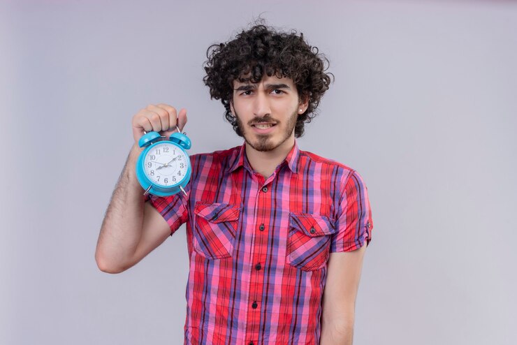 Foto gratuito despertador de camisa colorida aislado de pelo rizado masculino joven