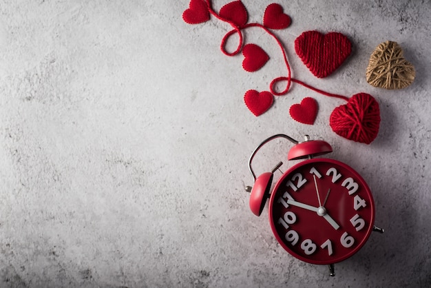 Despertador rojo con el corazón rojo, concepto del día de tarjetas del día de San Valentín.