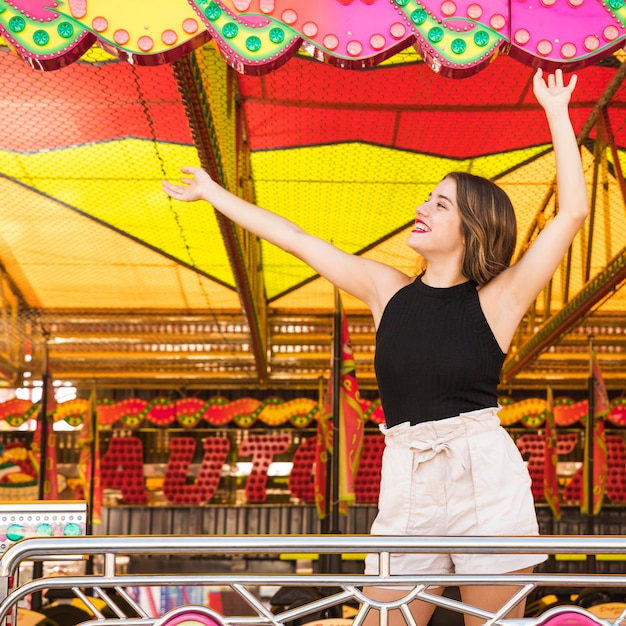 Despreocupada joven bailando en el parque de atracciones