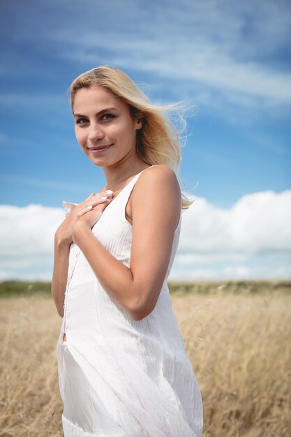 Despreocupada mujer rubia de pie en el campo