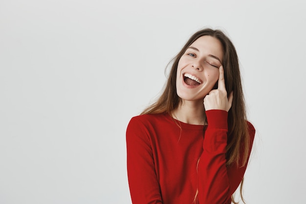 Despreocupada niña sonriente estirar el párpado