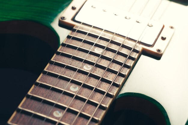 Detalle de cuerpo y cuello de guitarra eléctrica sobre fondo de madera