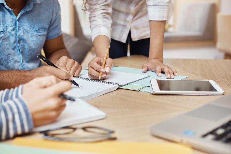 Foto gratuito detalle del equipo trabajando en un nuevo proyecto en el espacio de coworking, escribiendo ideas, mirando gráficos en la tableta y la computadora portátil. trabajo en equipo, concepto de negocio.