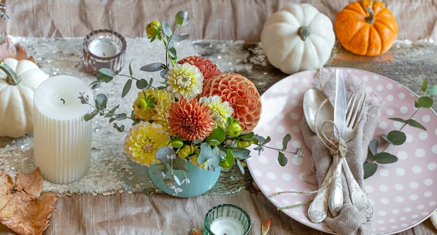 Detalle de primer plano de la decoración de una mesa festiva de otoño con calabazas, flores.