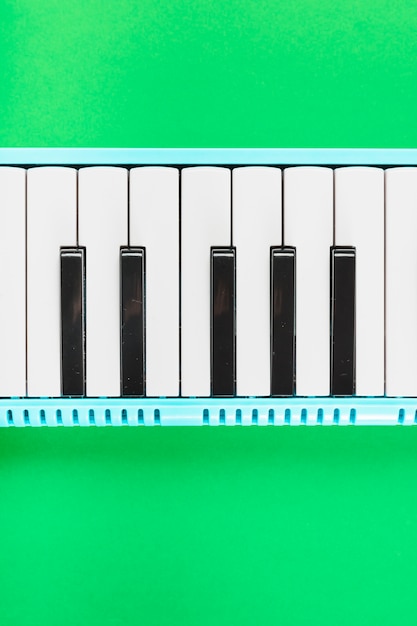 Foto gratuita detalle del teclado clásico de piano blanco y negro sobre fondo verde