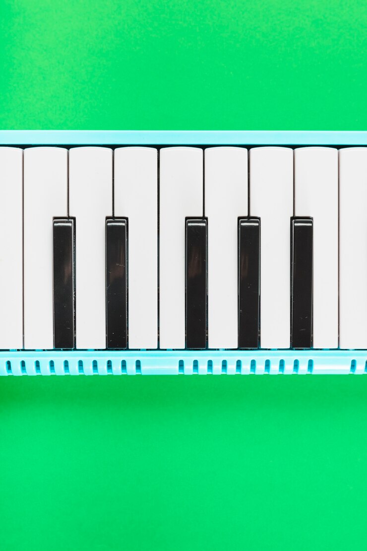 Foto gratuito detalle del teclado clásico de piano blanco y negro sobre fondo verde