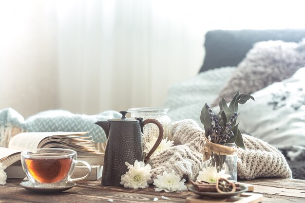 Detalles de bodegones del interior de una casa en una mesa de madera con una taza de té