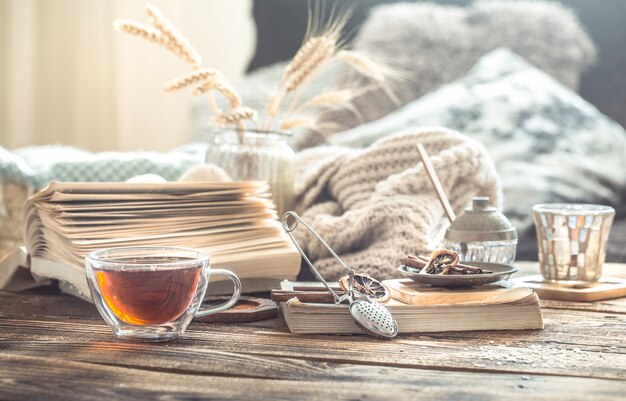 Detalles de bodegones del interior de una casa en una mesa de madera con una taza de té