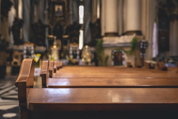 Detalles interiores de una iglesia católica con bancos de madera