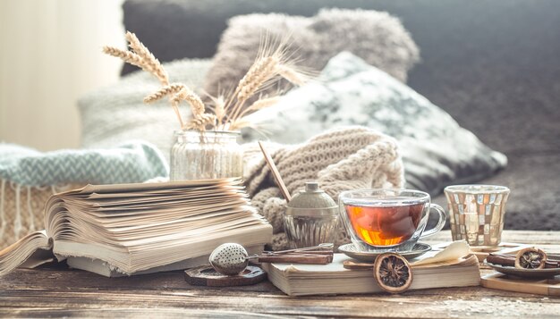 Detalles de la naturaleza muerta del interior de una casa en una mesa de madera con una taza de té