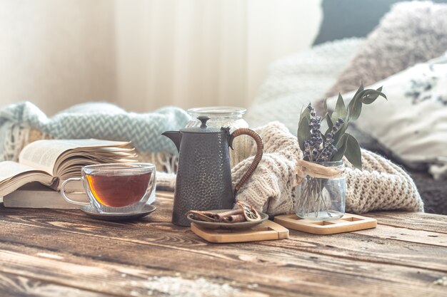 Detalles de la naturaleza muerta del interior de una casa en una mesa de madera con una taza de té