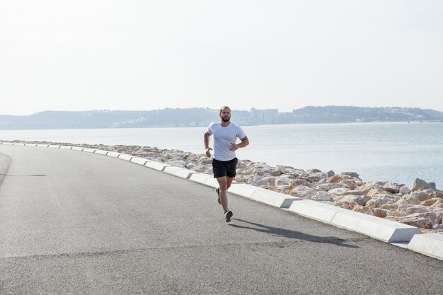 Determinado fuerte deportista corriendo en el mar