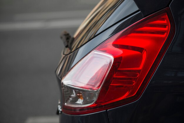 Detrás del coche oscuro con luz trasera