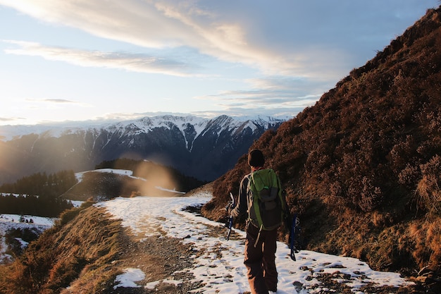 Detrás de la foto del excursionista en las montañas cubiertas de nieve.